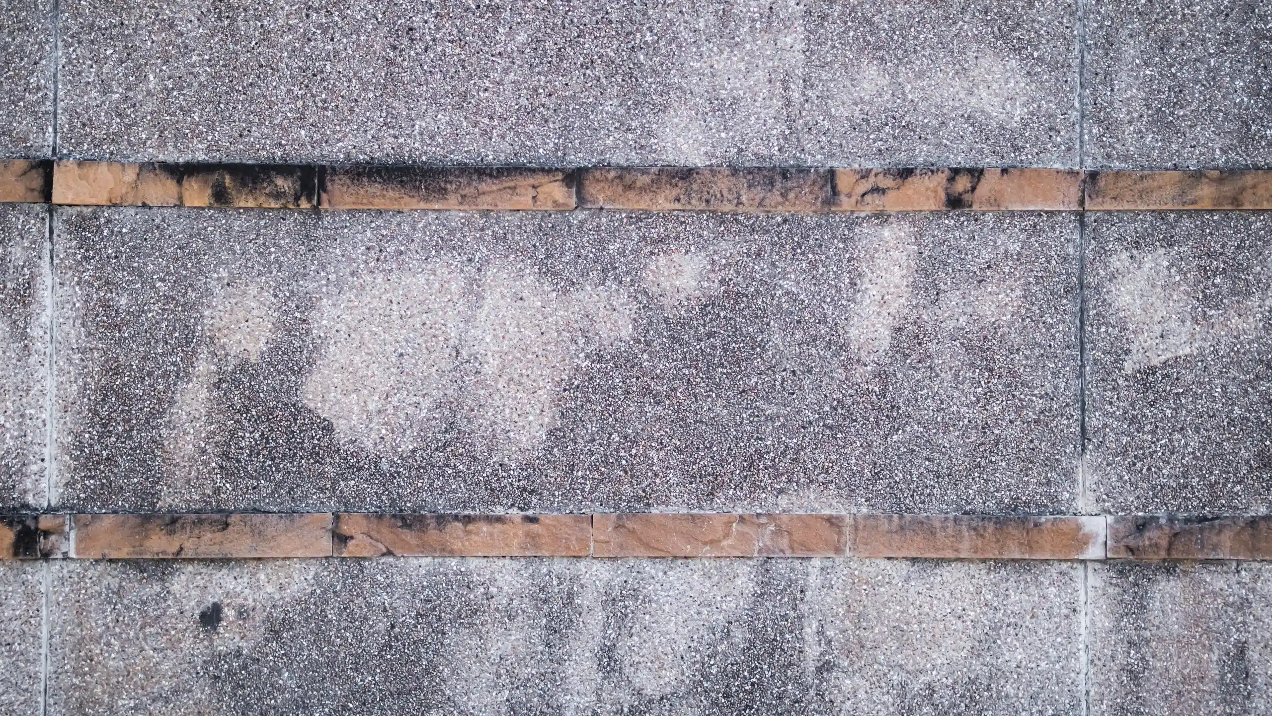 Hail damage close-up showing dented shingles on New Orleans roof