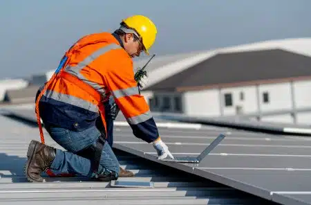 Commercial roof inspector examining TPO membrane seams on a flat-roofed New Orleans office building