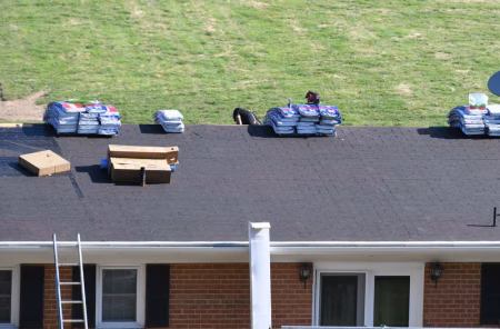 Standing water pooling on a flat commercial roof in New Orleans with clogged roof drain visible