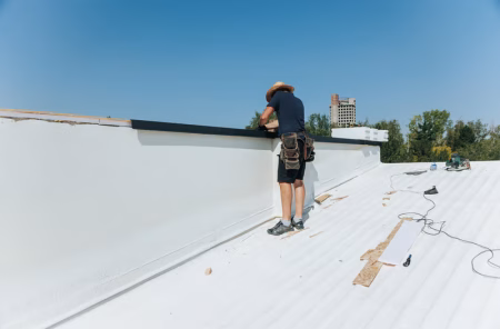 Split view of white TPO membrane roof on left and black EPDM rubber roof on right on New Orleans commercial buildings